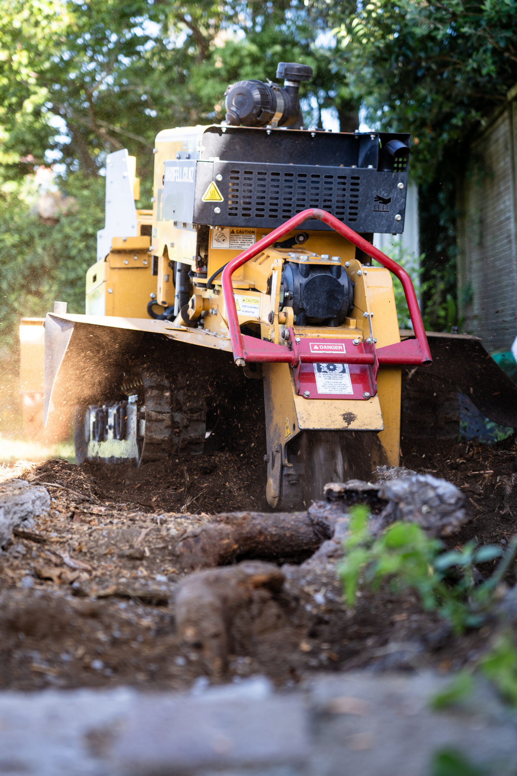 Hardfell Rayco stump grinder actively removing a stump and roots